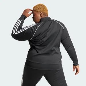 Chaqueta deportiva Adidas negra con rayas blancas en las mangas.