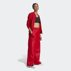 Conjunto deportivo rojo vibrante con chaqueta bomber y pantalón ancho.